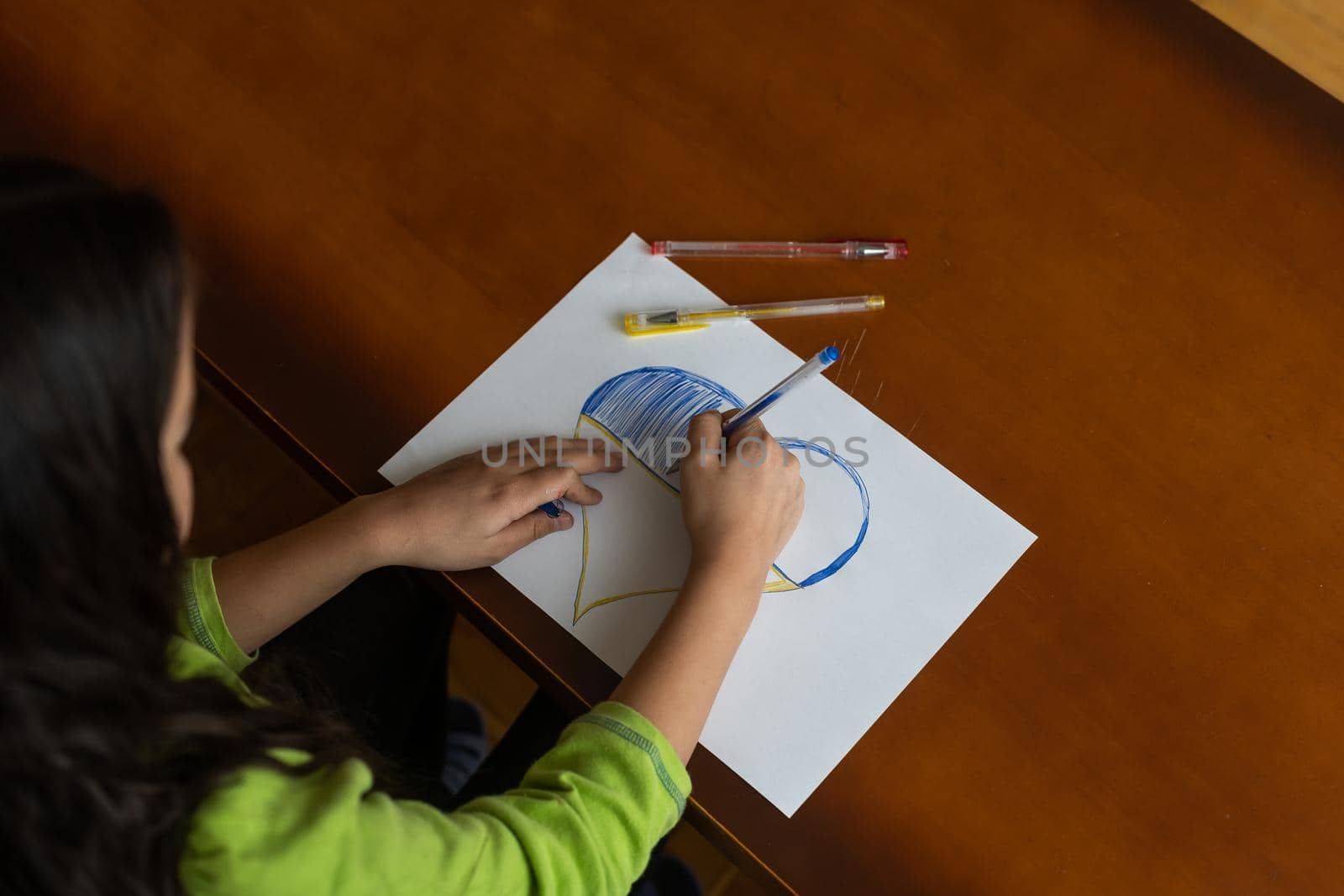 Childrens hand with pencil draws the heartl.
