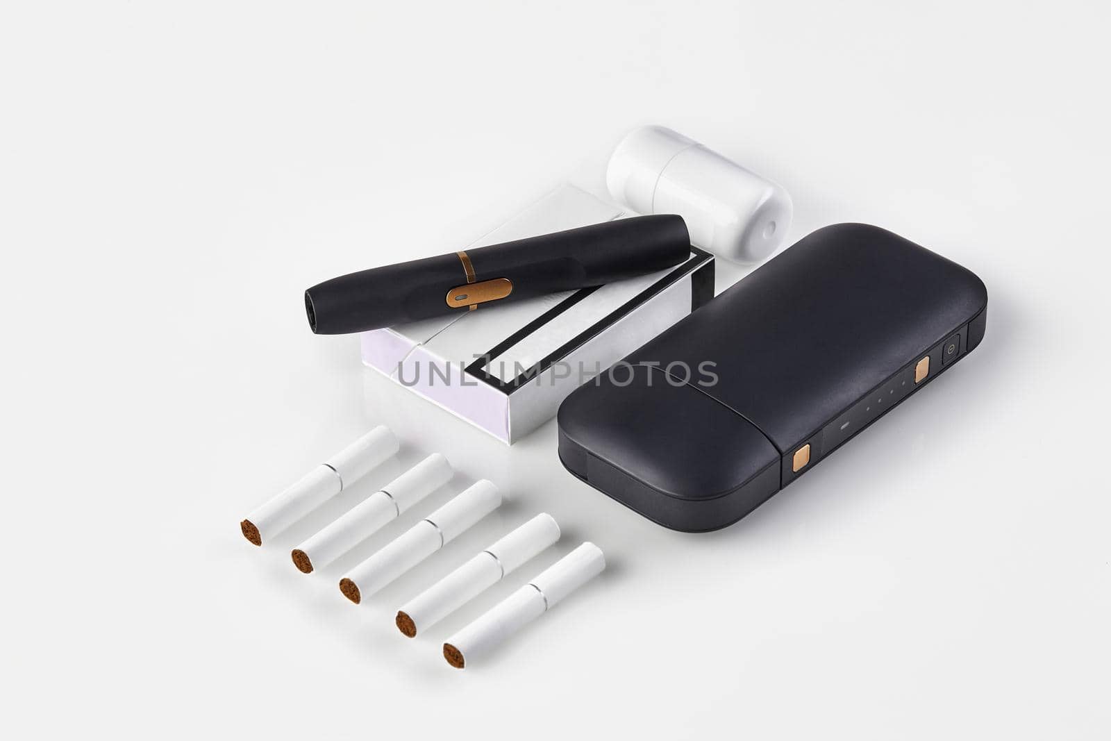 New generation black electronic cigarette and battery, cleaner, one pack and five heatsticks isolated on white. Heating tobacco system. Close up by nazarovsergey