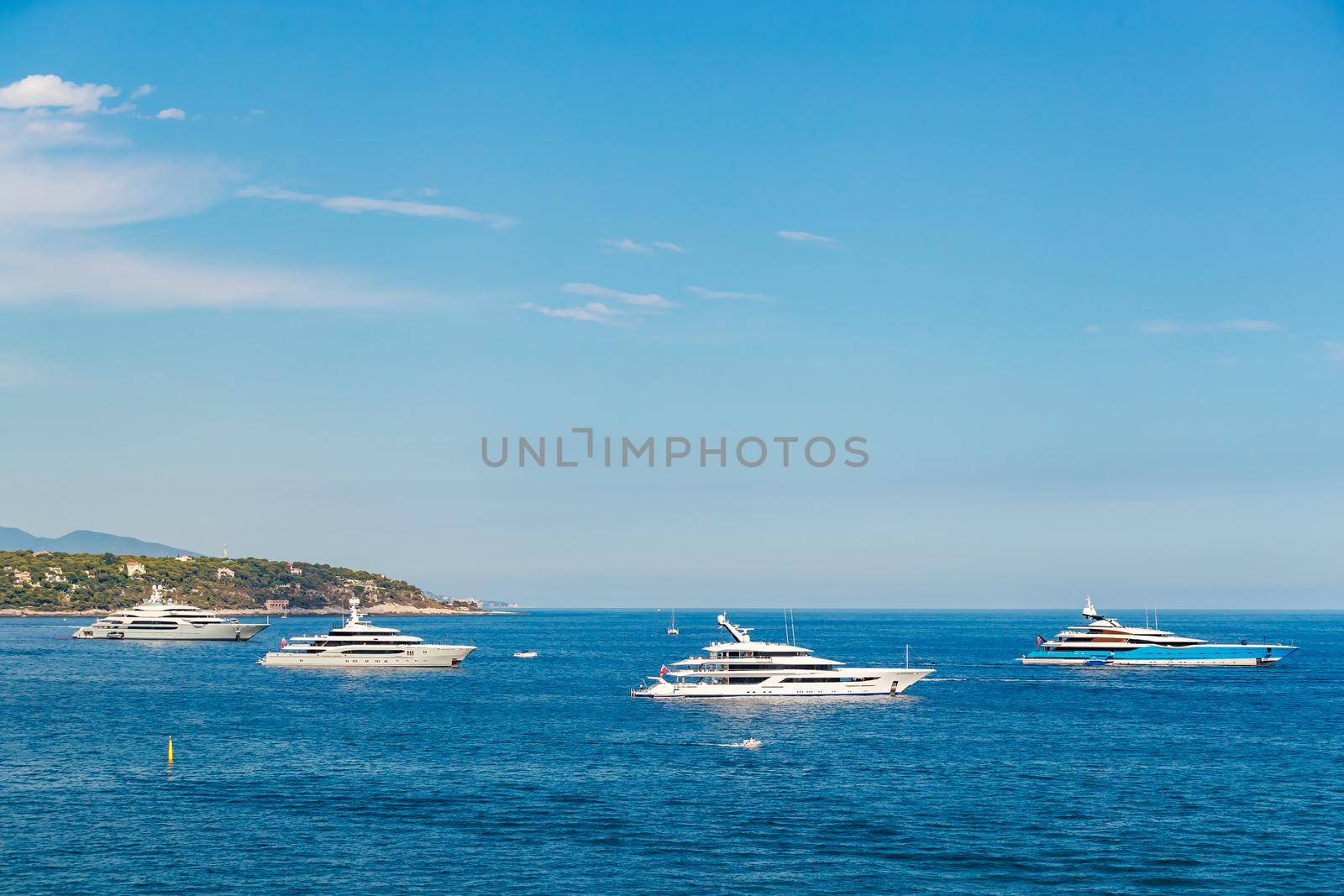 The four huge mega yachts are moored in sea at sunny day, the chrome plated handrail, sun reflection on glossy board of the motor boat. High quality photo
