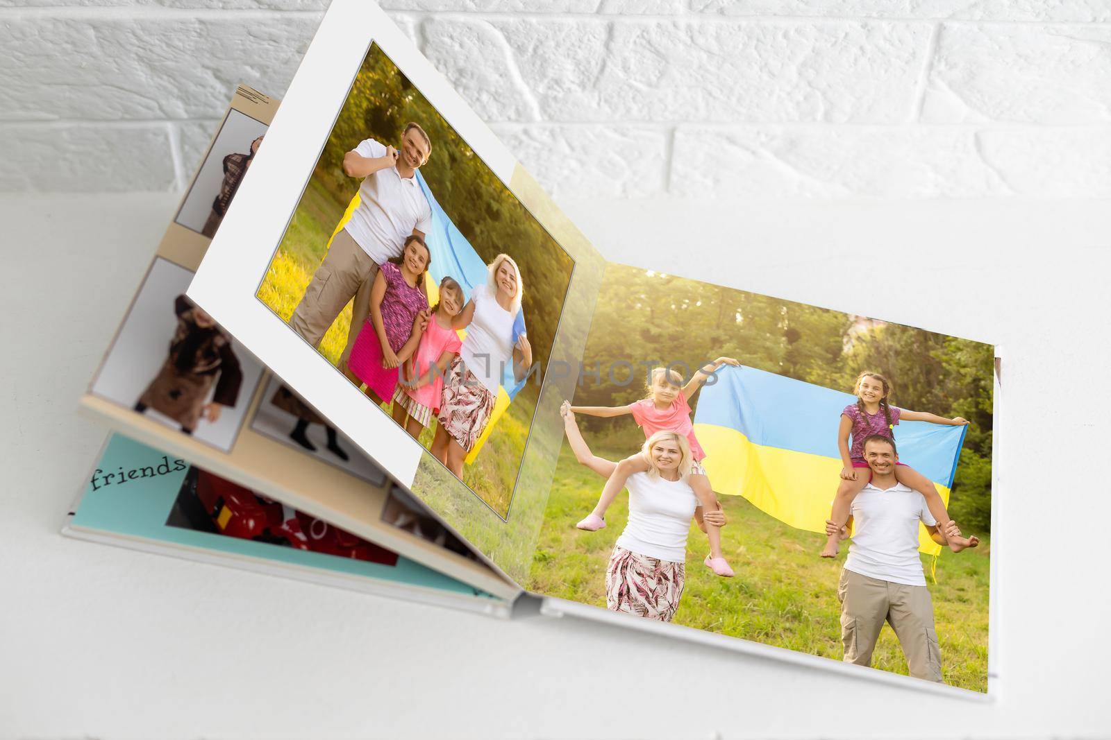 Family photos archive saved in brightly designed photo book; bright summer memories placed in the photobook. family with flag of ukraine by Andelov13
