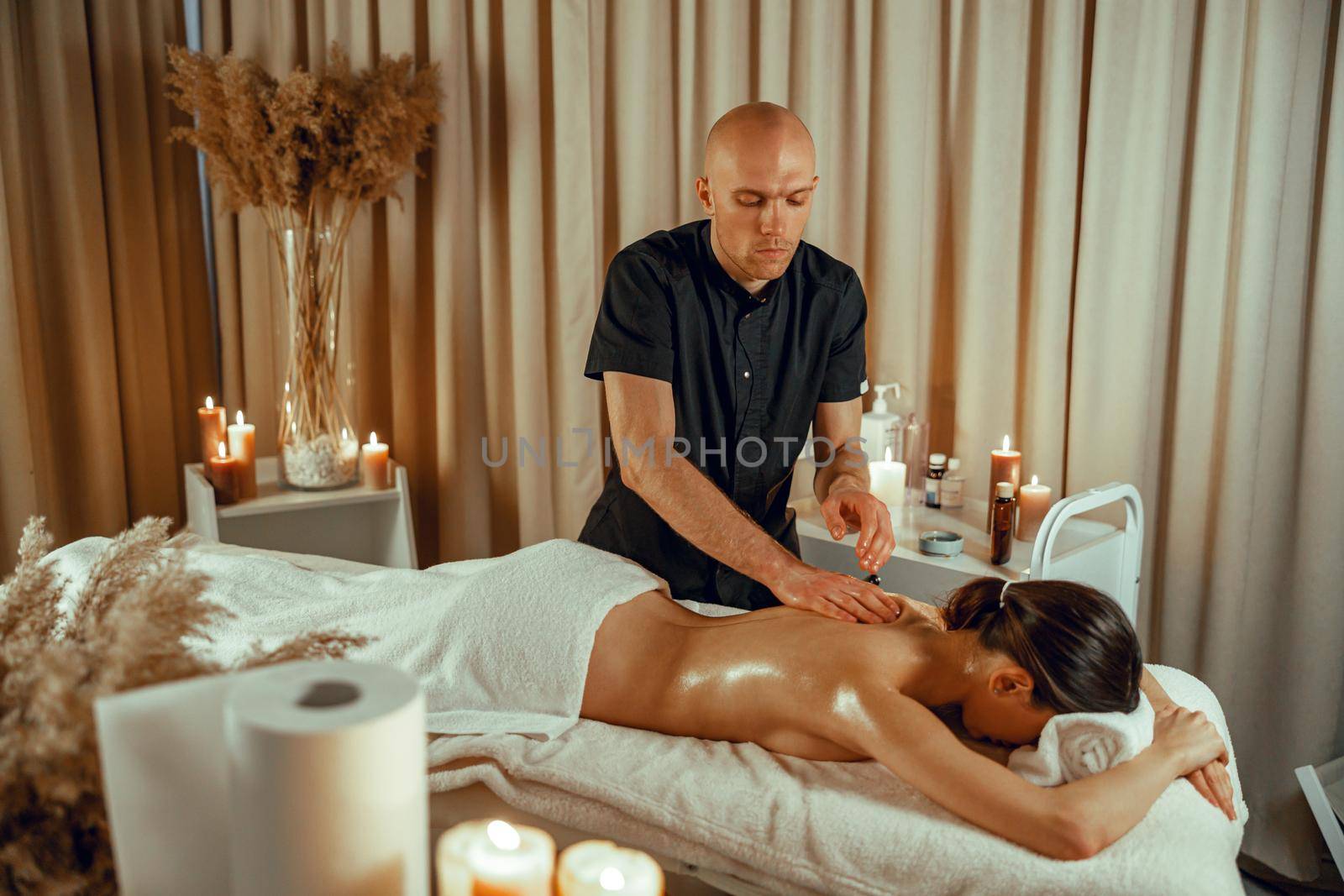 Professional masseur man doing back massage at beauty spa resort by Yaroslav_astakhov
