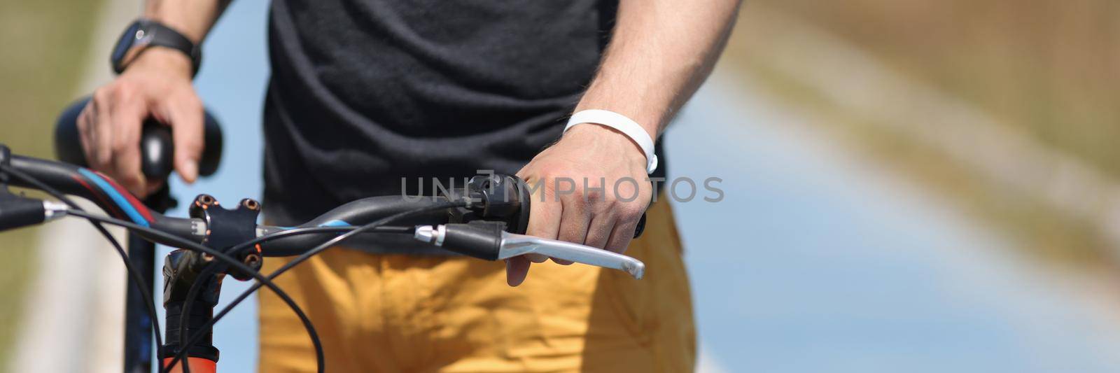 Man with mountain bike standing on bicycle path closeup. Bike trip concept