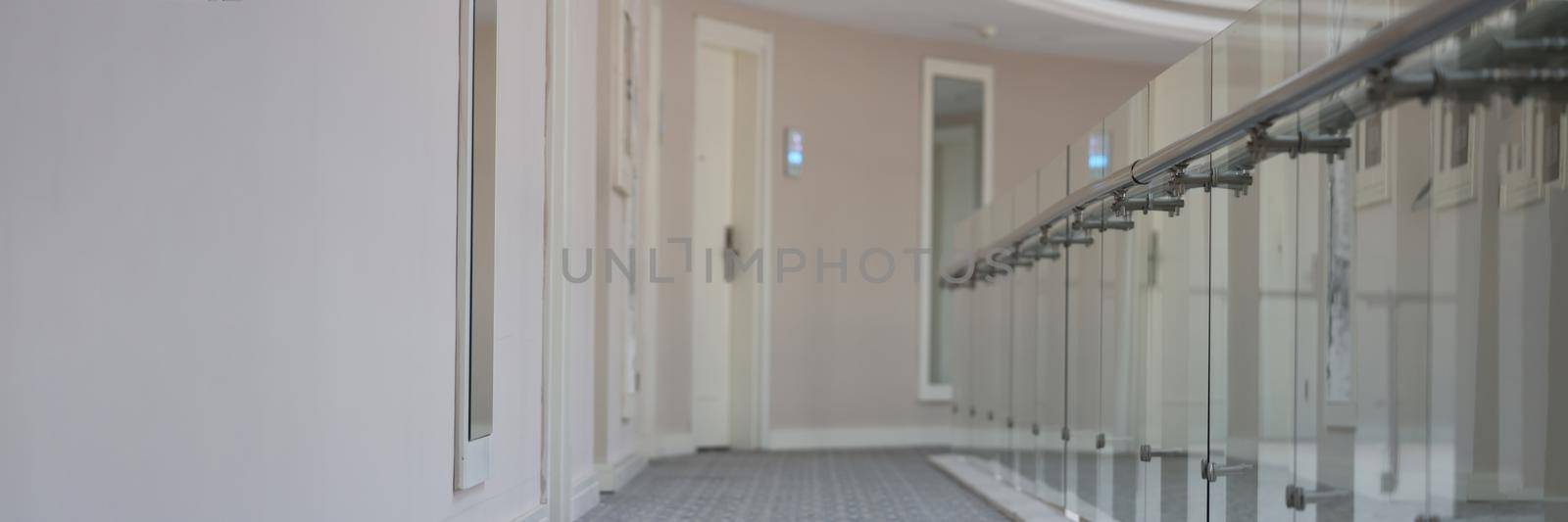 Empty corridor with doors to rooms in hotel building. Modern architecture public building concept