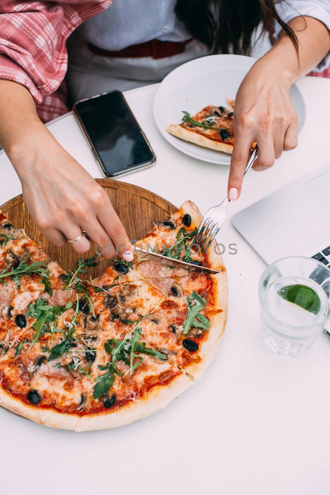 Top view of business woman eating pizza while working at a pizza restaurant by Ashtray25