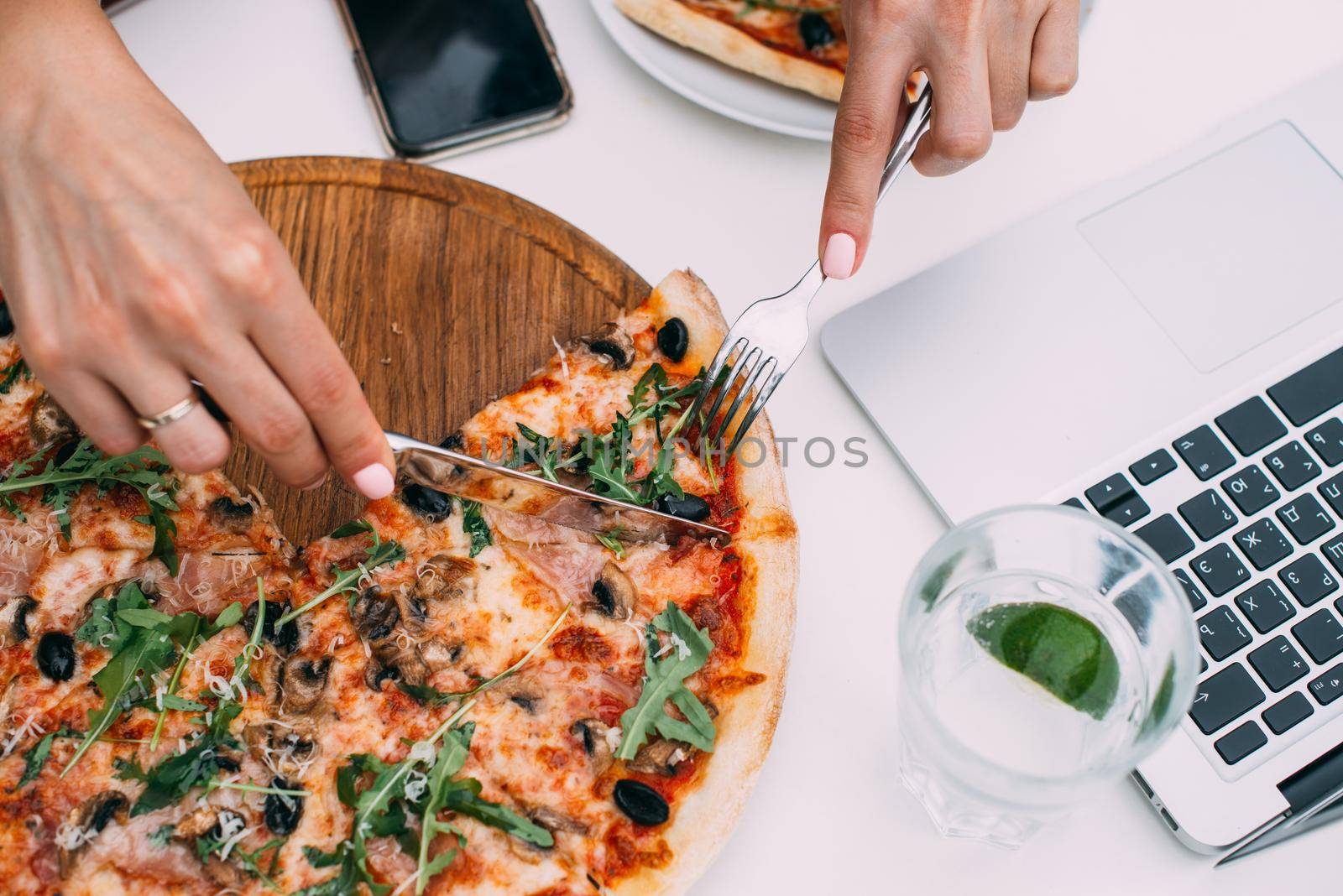 Top view of business woman eating pizza while working at a pizza restaurant by Ashtray25