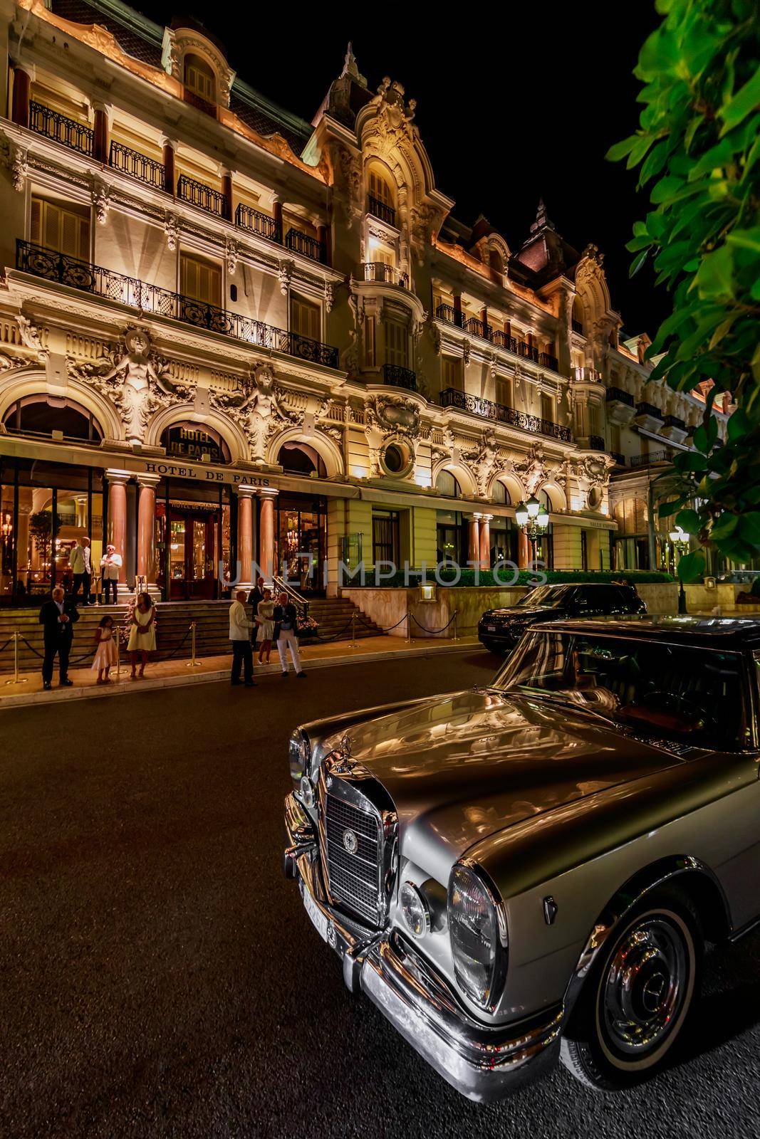 Monaco, Monte Carlo, 21 August 2019: Vintage Mercedes Benz car near the hotel Paris with night illumination, lights of the place Casino. High quality photo