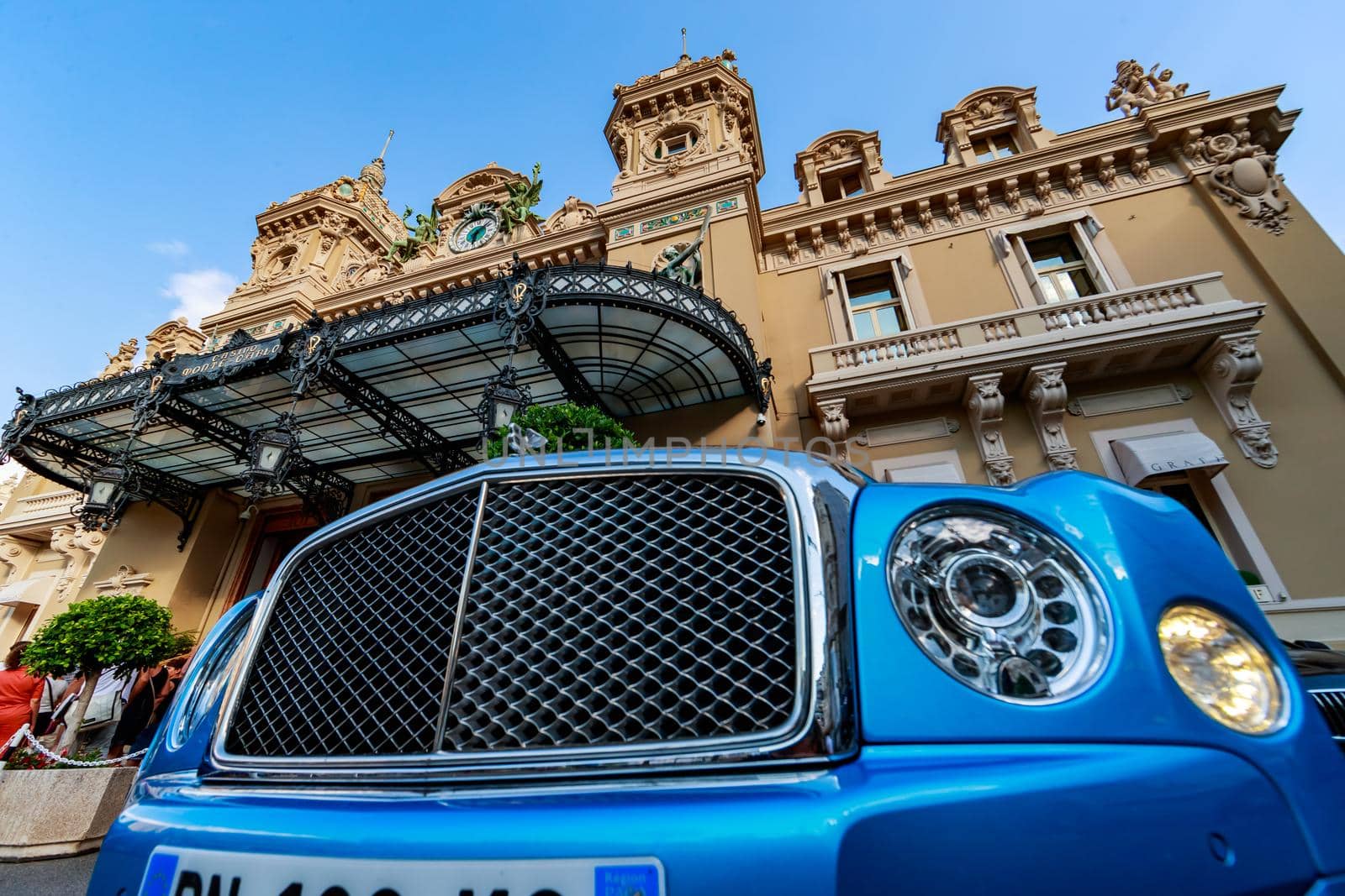Monaco, Monte-Carlo, 21 August 2017: Luxury car Bentley of blue color near casino Monte-Carlo at sunset, view from Hotel de Paris, city life in summer time. High quality photo