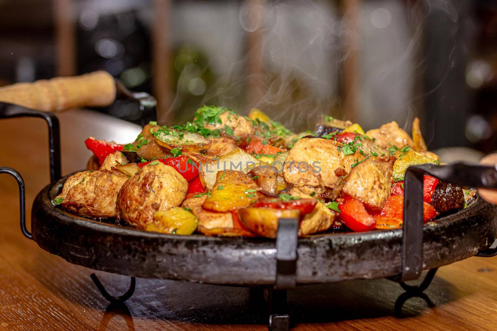 Pan-fried potatoes, meat and vegetables for a large company.