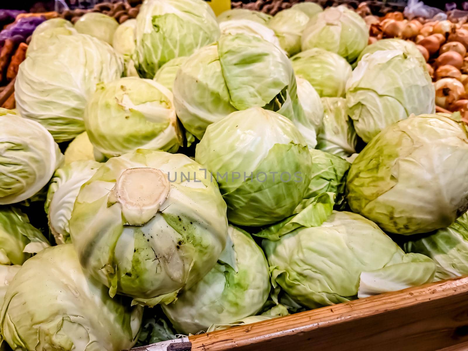 Fresh fruits of white cabbage are in a box in the store by Milanchikov