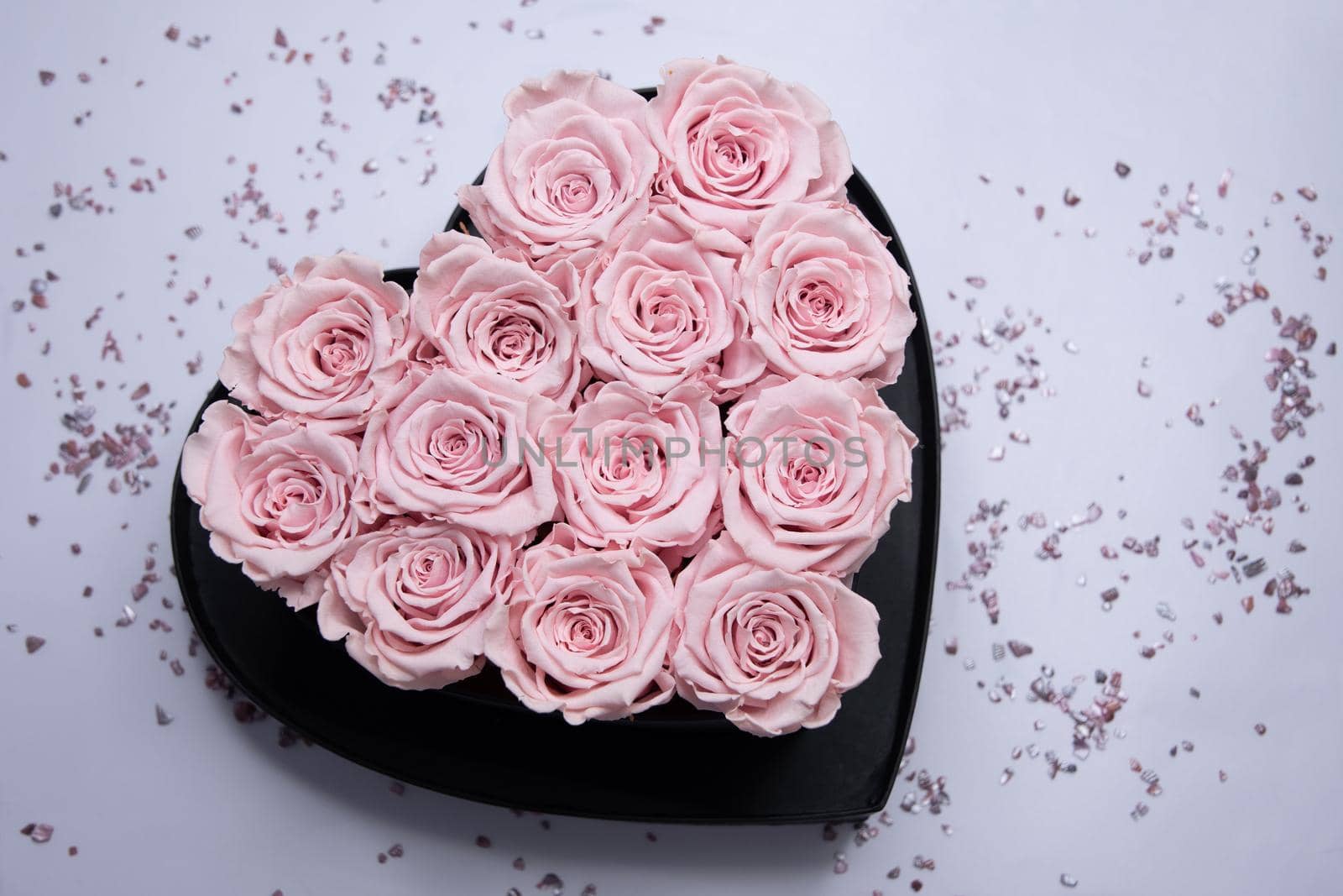 heart-shaped cardboard box with pink roses on the table, a gift for valentine's by KaterinaDalemans