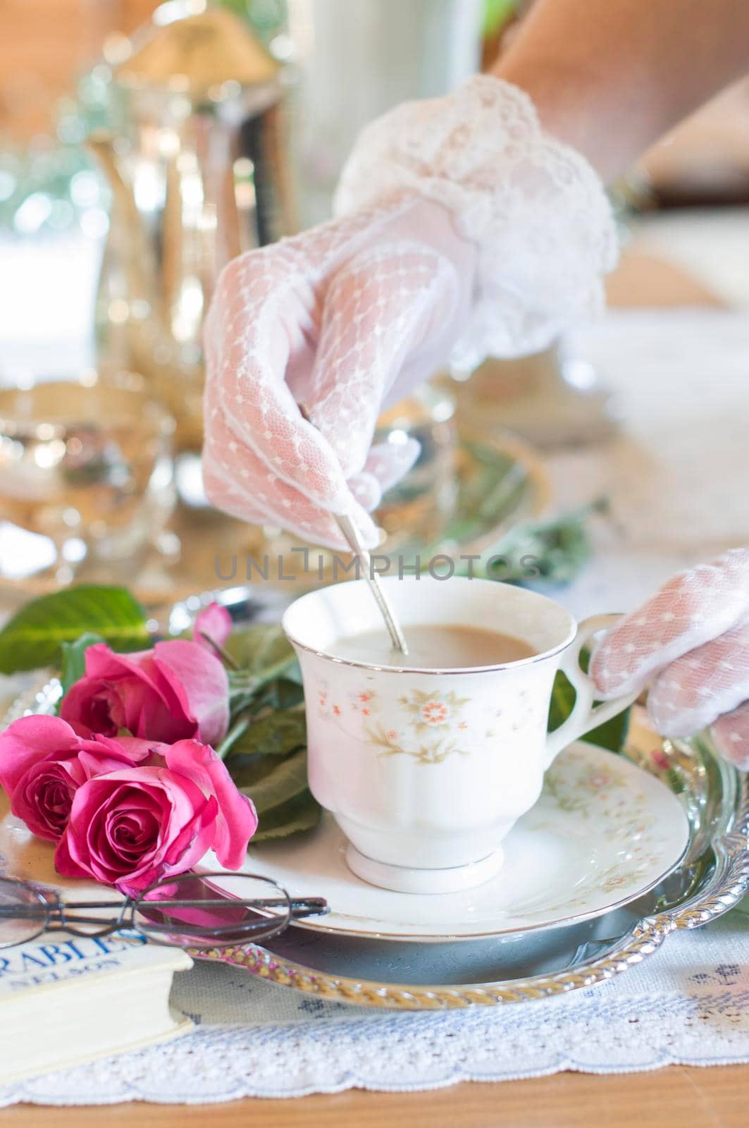 English retro still life and a woman's hand in a white lace glove stirring coffee with milk in an elegant cup from Chinese porcelain, light and airy early morning mood. High quality photo
