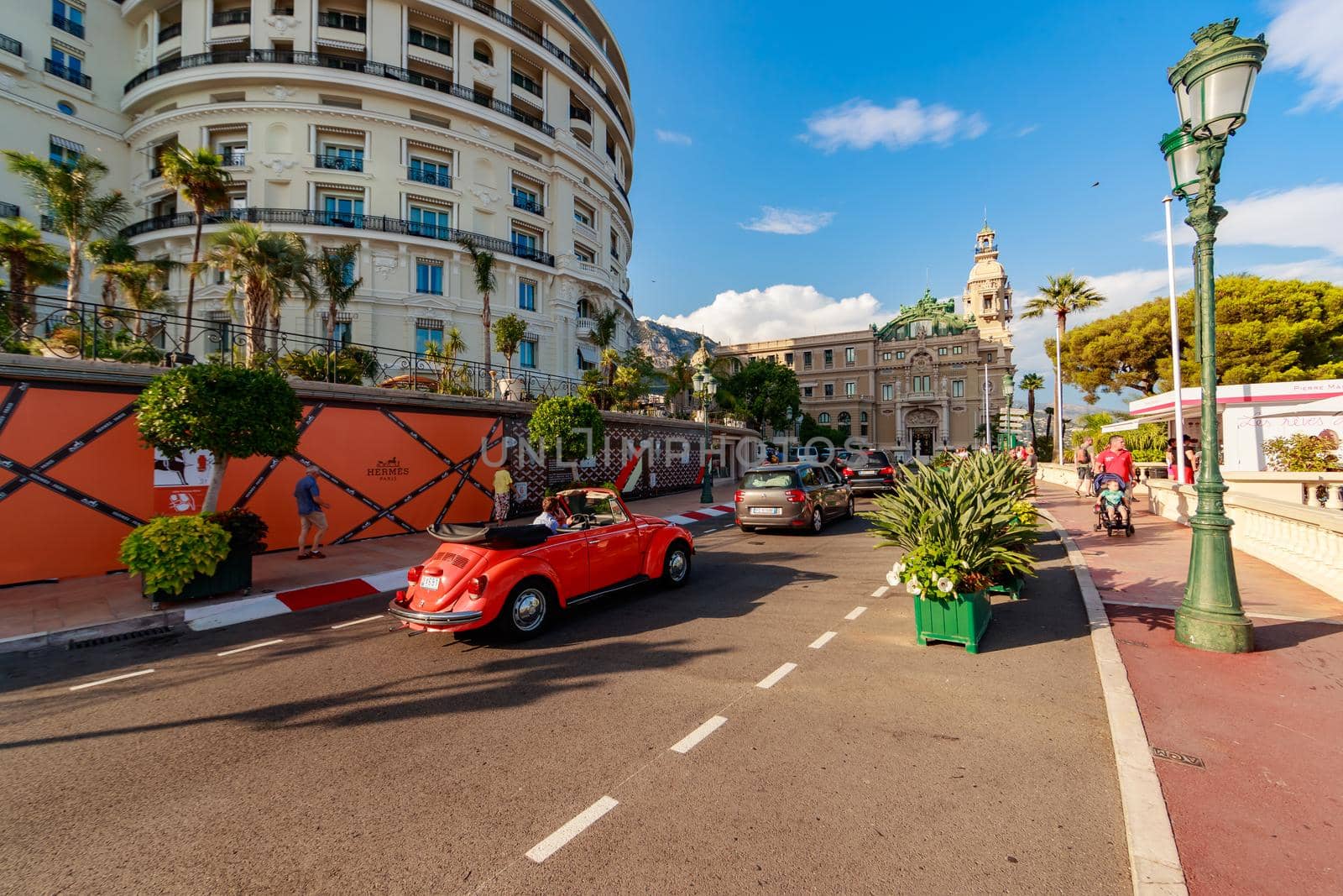 Monaco, Monte-Carlo, 21 August 2017: Tourists and wealthy people visit branded shops near the hotel Paris and Casino Monte-Carlo at sunset, vintage cars, luxury life, expensive cars, wide angle. High quality photo