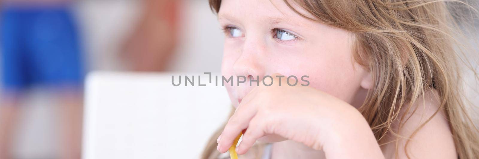 Little girl drinking nonalcoholic cocktail from straw at beach bar by kuprevich