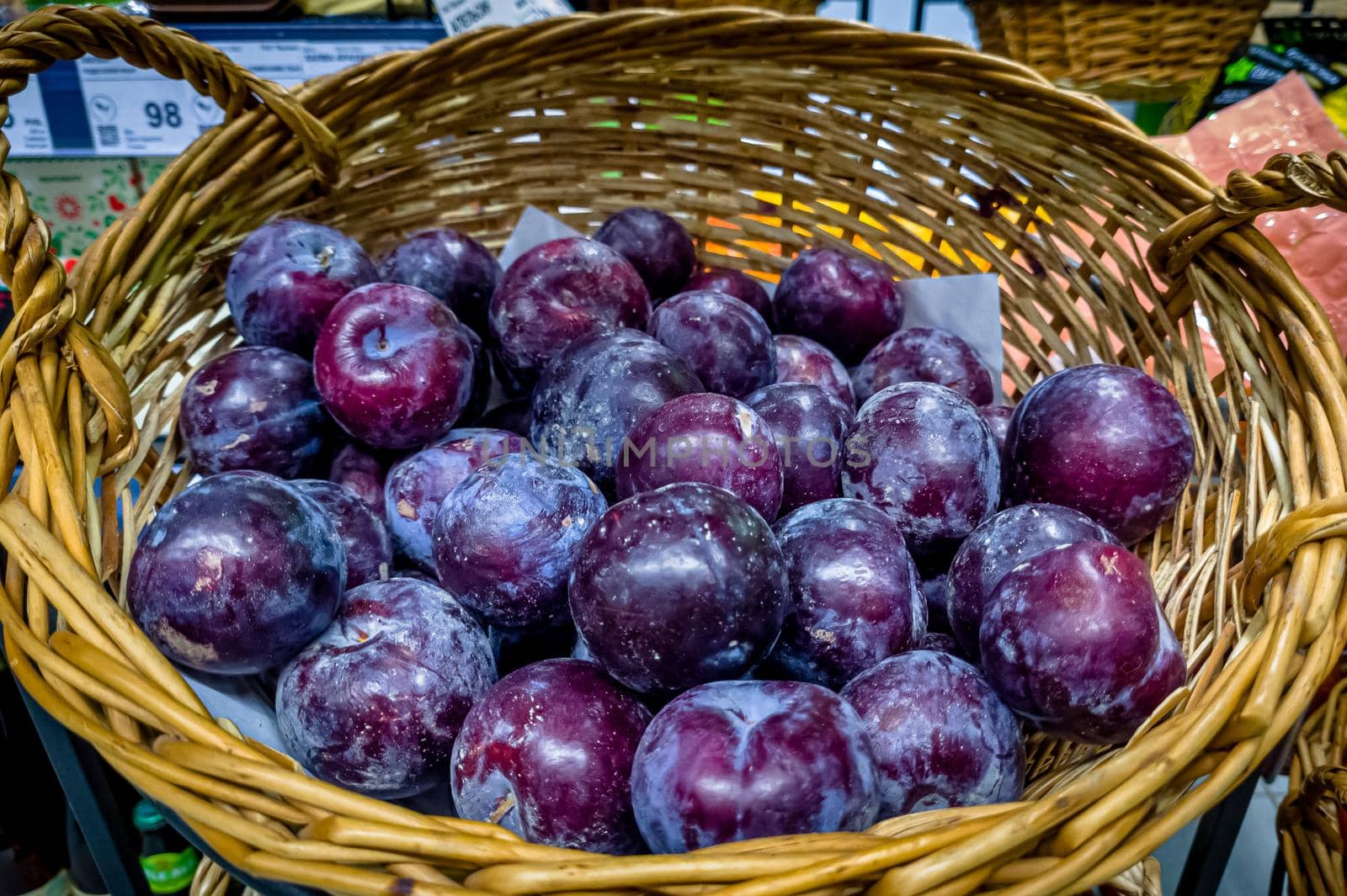 Blue plums are in a basket in the store. by Milanchikov