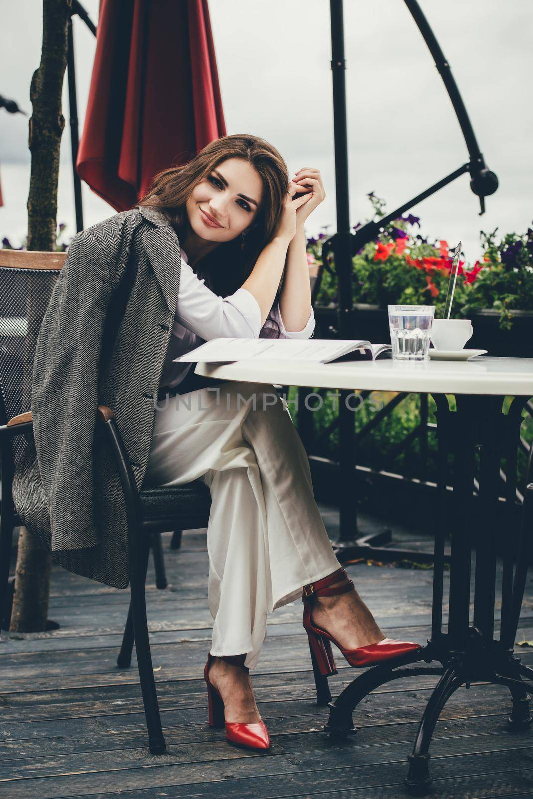 Young brunette woman using laptop computer sitting at cafe table and drik coffe. . Business People Concept