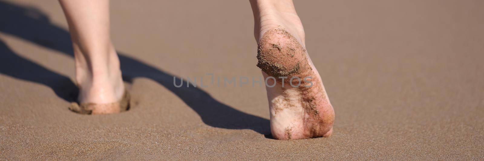 Female bare feet walking along seaside closeup. Boat trips concept