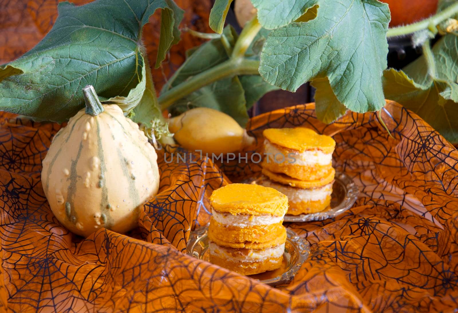 mini pumpkin cheesecakes on pumpkin background, autumn, orange color food, halloween, High quality photo