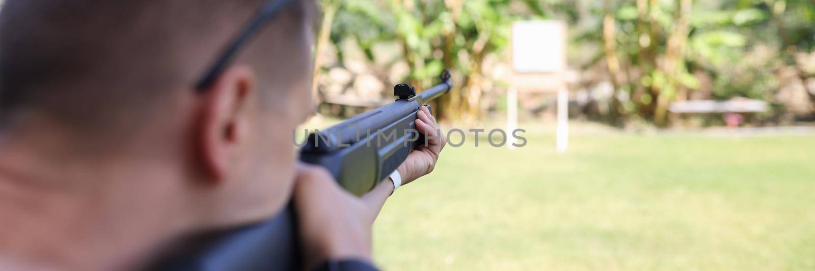 Man shooting gun at target on vacation closeup by kuprevich