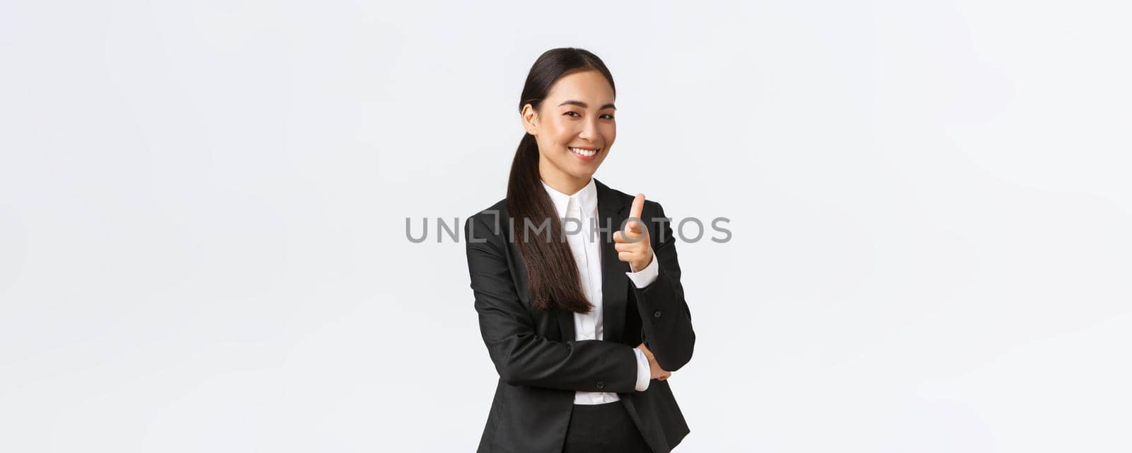 Well done, good point, congrats gesture. Successful female entrepreneur standing satisfied pointing finger at camera and smiling. Saleswoman inviting client check out good deal, white background.