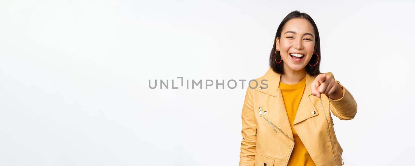 Congratulations, its you. Happy beautiful asian woman laughing, pointing finger at camera, choosing, inviting people, recruiting, standing over white background.