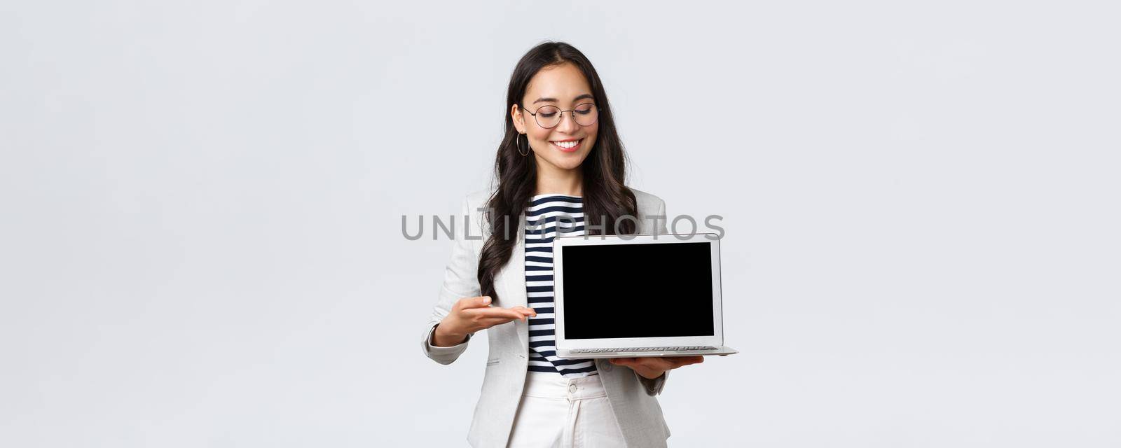 Business, finance and employment, female successful entrepreneurs concept. Professional businesswoman, real estate broker pointing finger at laptop screen, showing good deal, having meeting by Benzoix