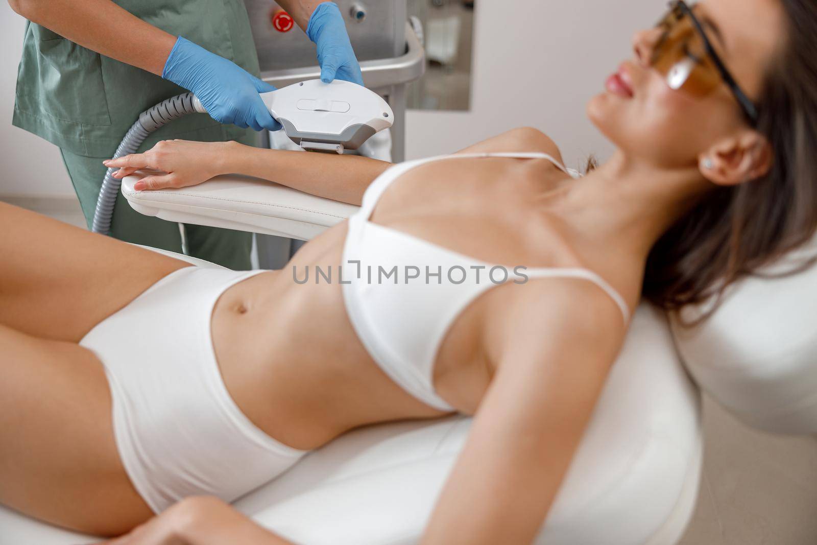 Arms hair removal procedure with ipl machine from a professional cosmetologist in beauty salon by Yaroslav_astakhov