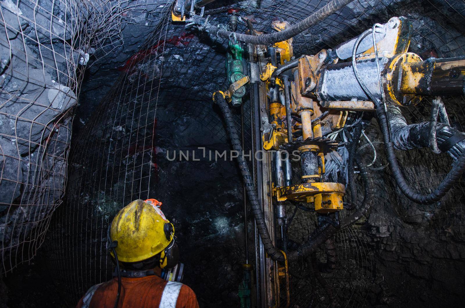 Mining operator on mining machine, underground mine mesh. by Peruphotoart