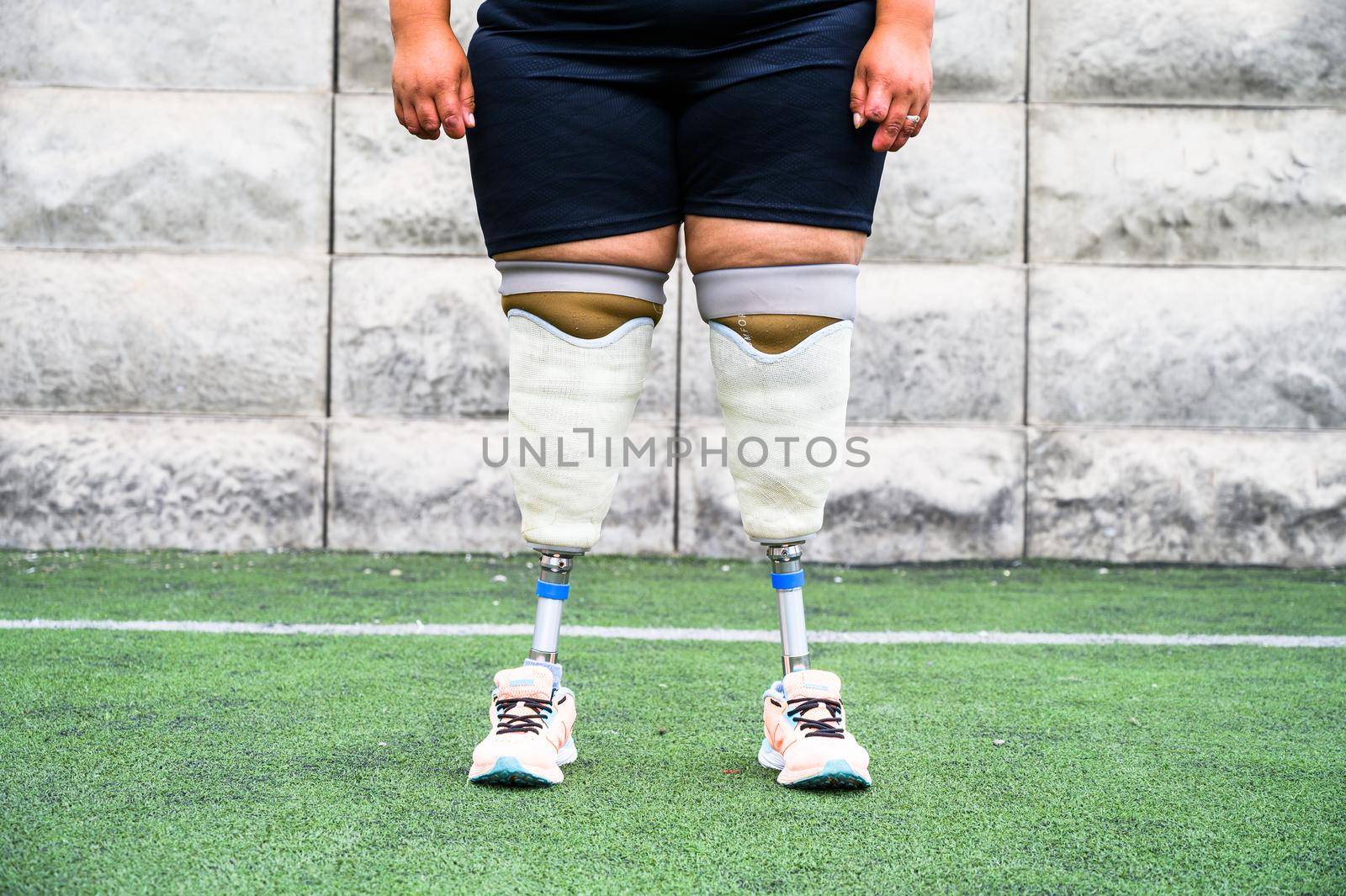 Unrecognizable female athlete with prosthetic legs. by Peruphotoart