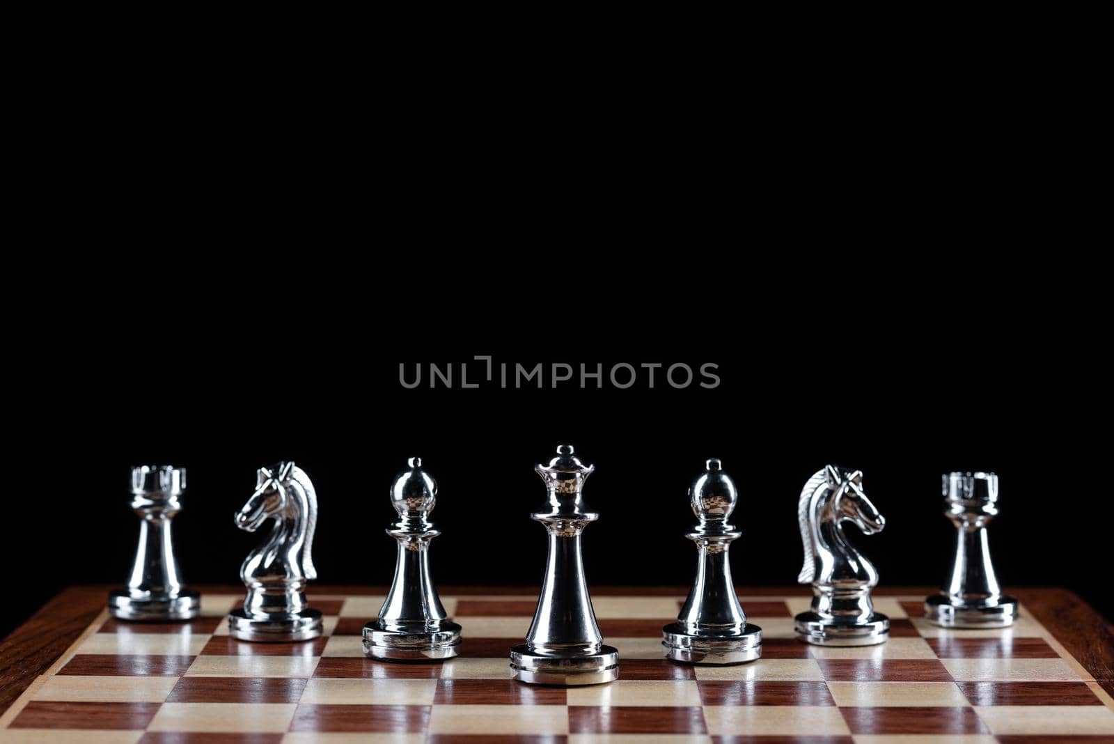 Silvery chess figures standing on chessboard by adam121