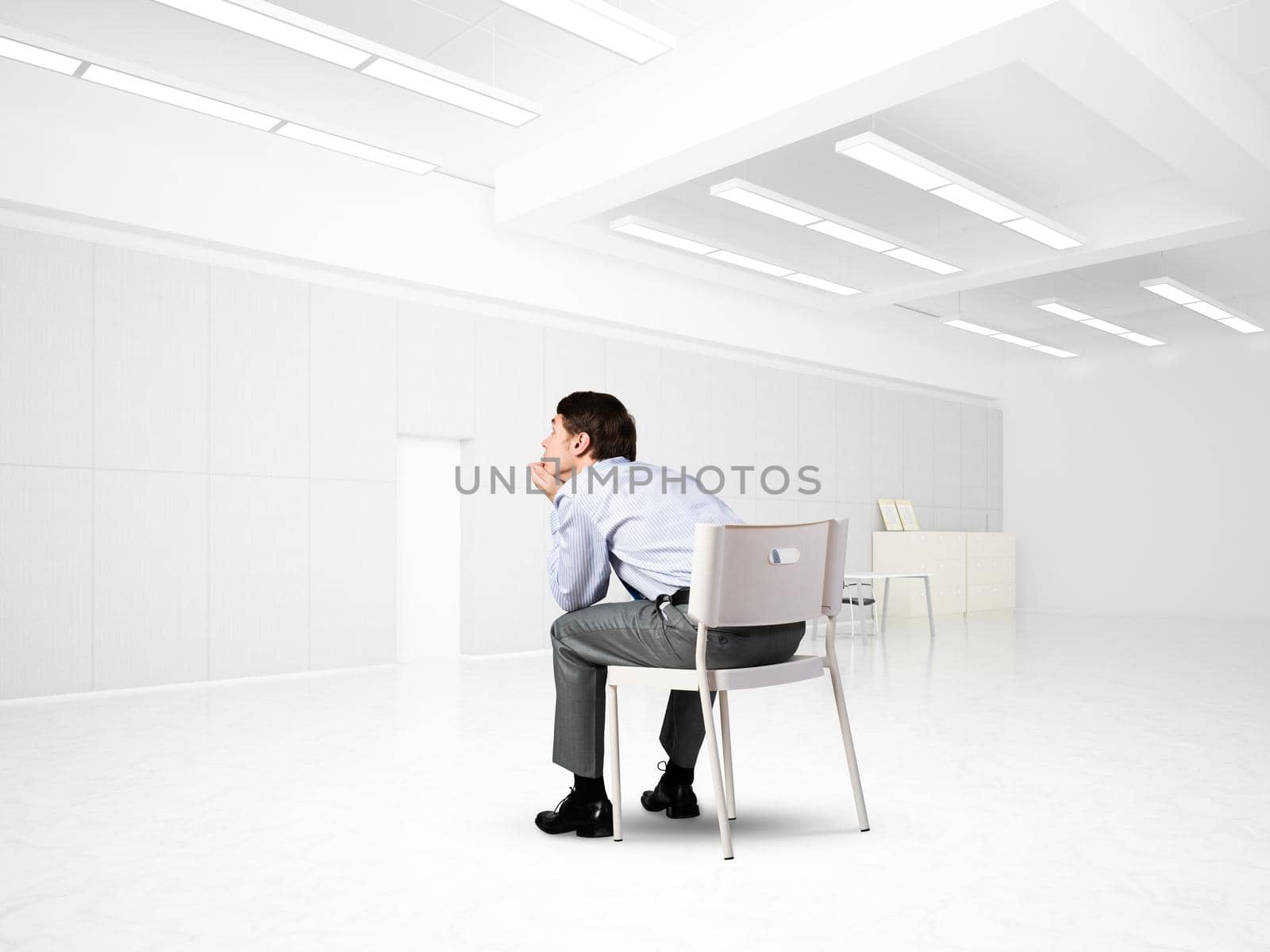 Young businessman sitting on an office chair by adam121