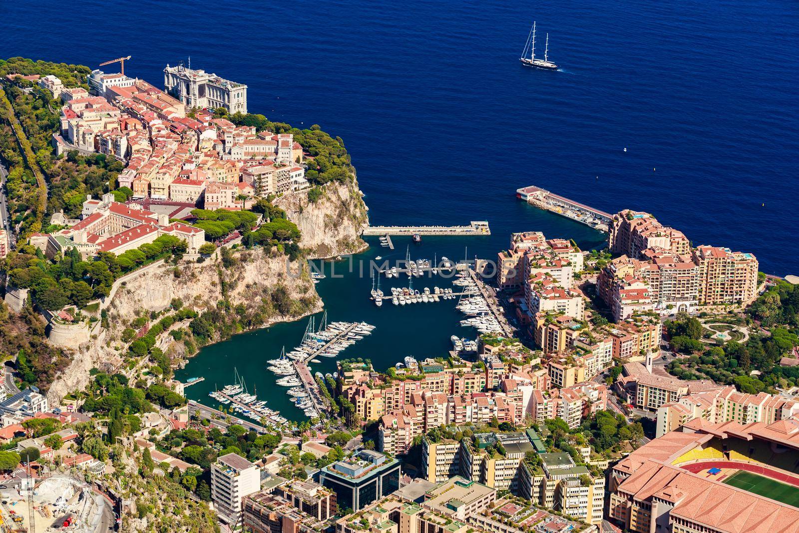 Aerial view of port Fontvieille at sunset, Oceanographic Museum of Monaco, South France, a lot of boats are moored in marina, view of city life from La Turbie mountain, mega yachts, luxury apartments. High quality photo
