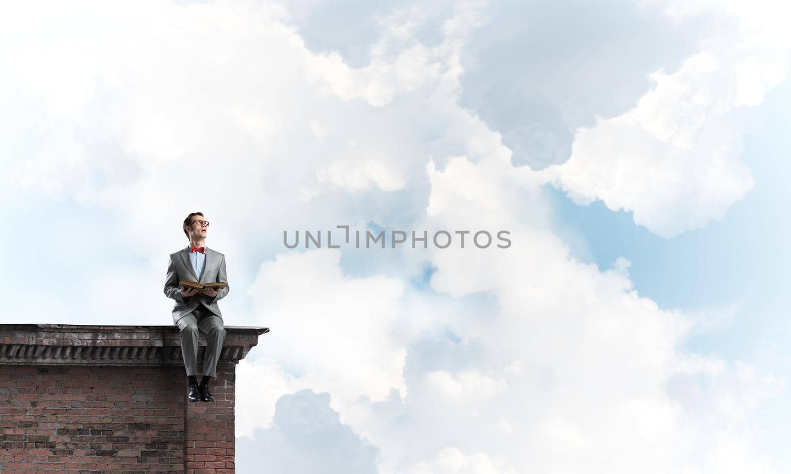 Young businessman or student studying the science on building roof by adam121