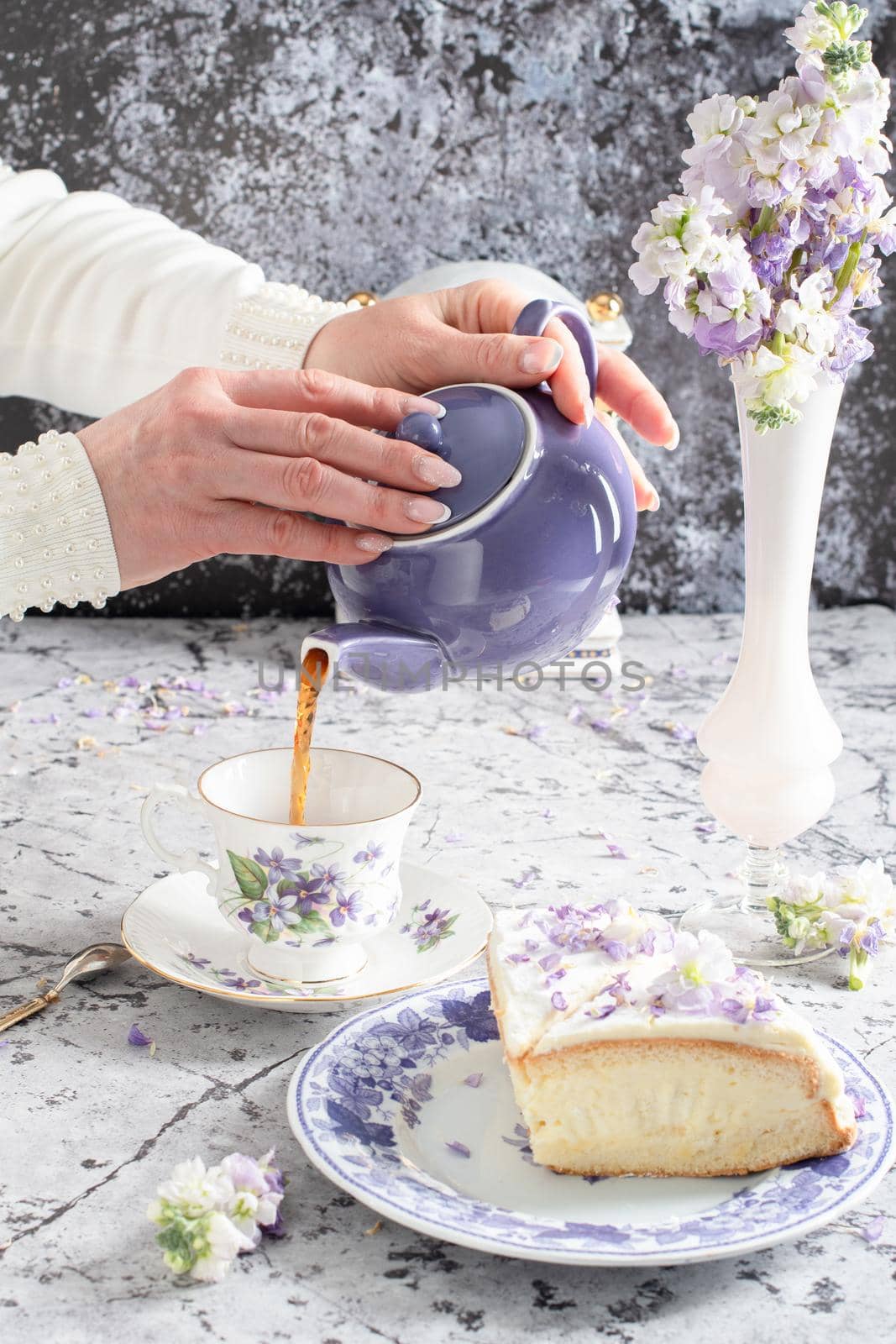 still life with black tea and cheese cake, spring bouquet of delicate lilac flowers. High quality photo