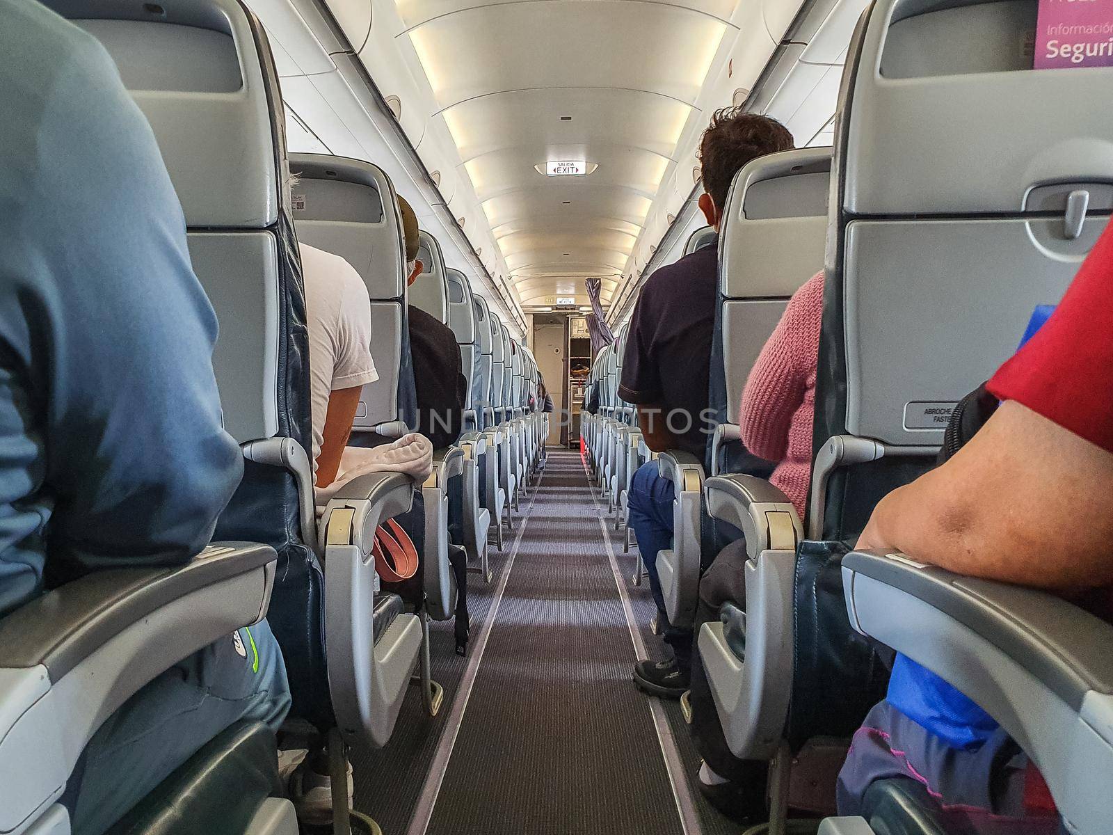 cabin of airplane with passengers on seats waiting to take off