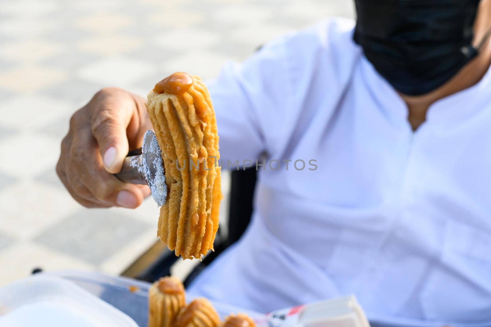 Unrecognizable seller of Peruvian churros, an exquisite dessert filled with blancmange. by Peruphotoart