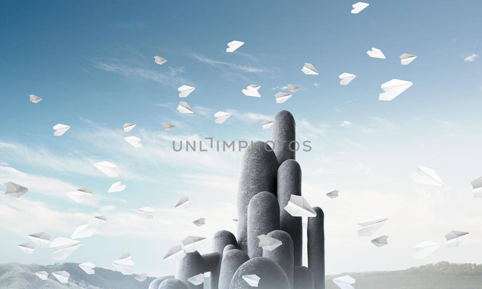 Image of high and huge stone columns located outdoors among flying paper planes with beautiful landscape on background. Wallpaper, backdrop with copyspace.