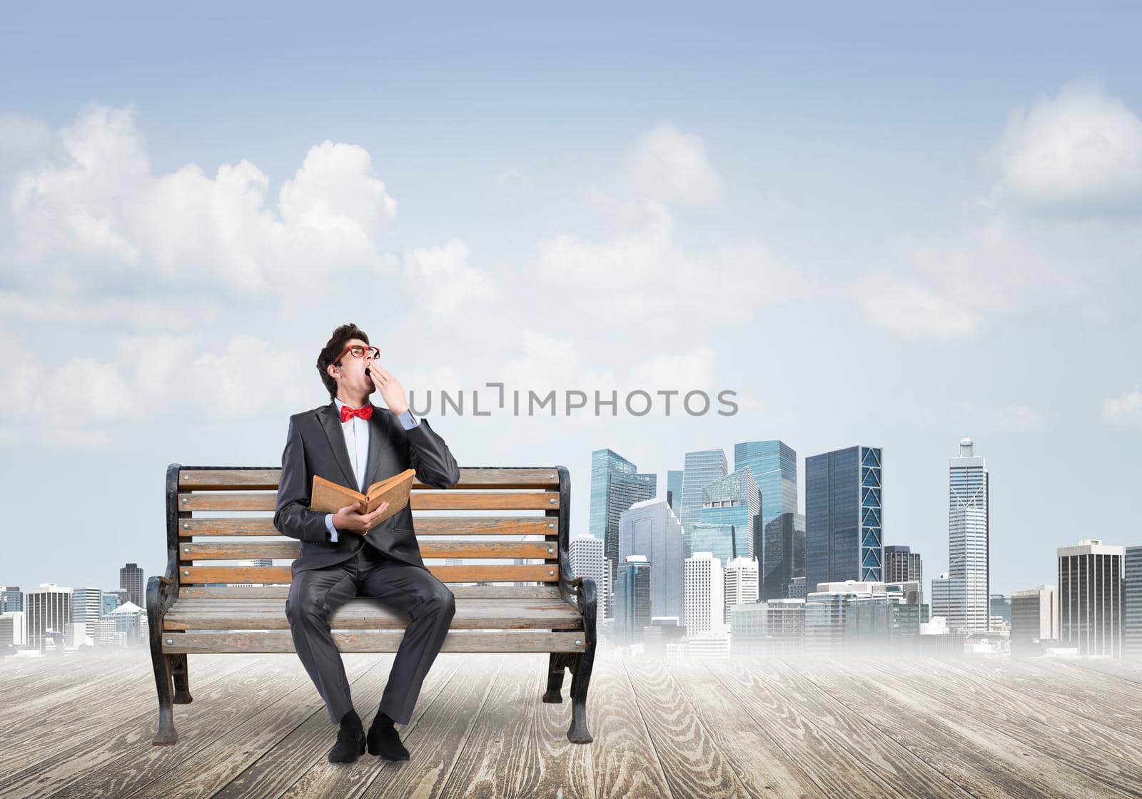 Student sits on a bench, holding a book. Traditional education concept