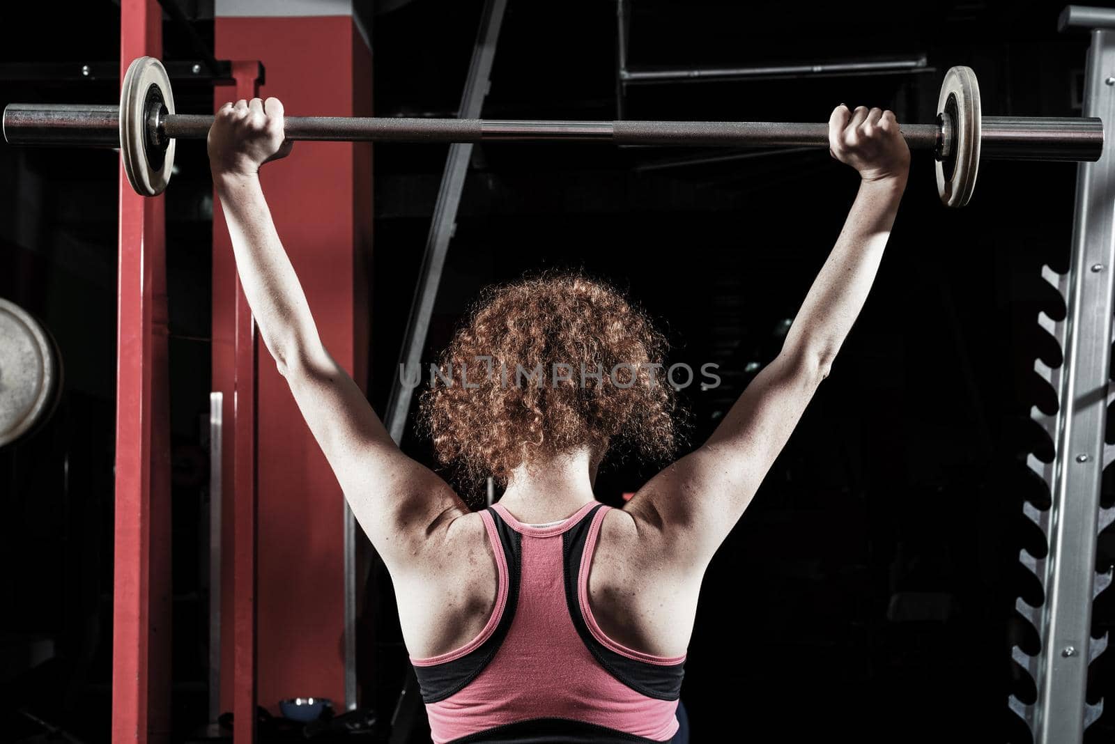 Woman bodybuilder engaged with a barbell in the gym. Healthy lifestyle.