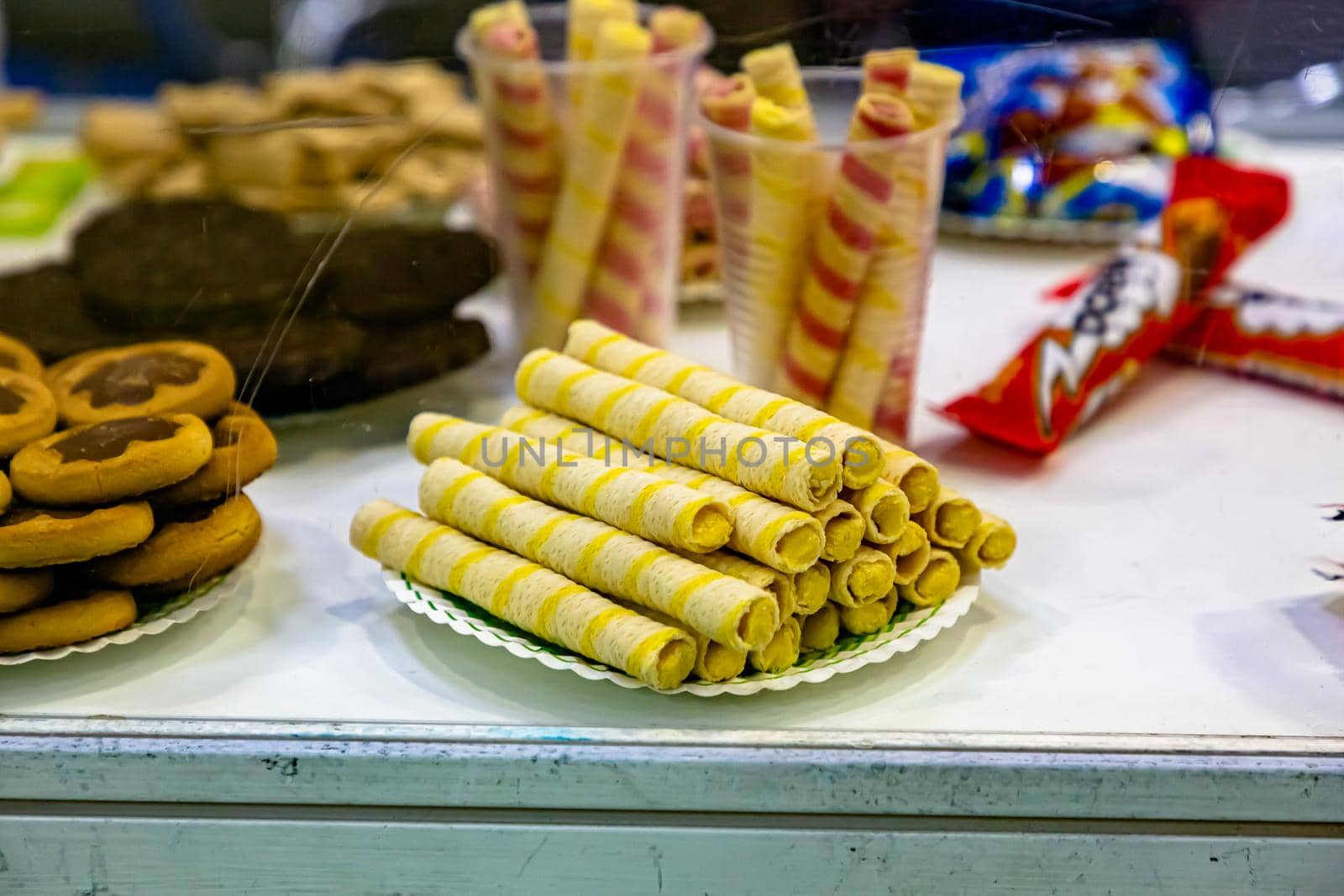 Waffle tubes are on display in a pastry shop by Milanchikov