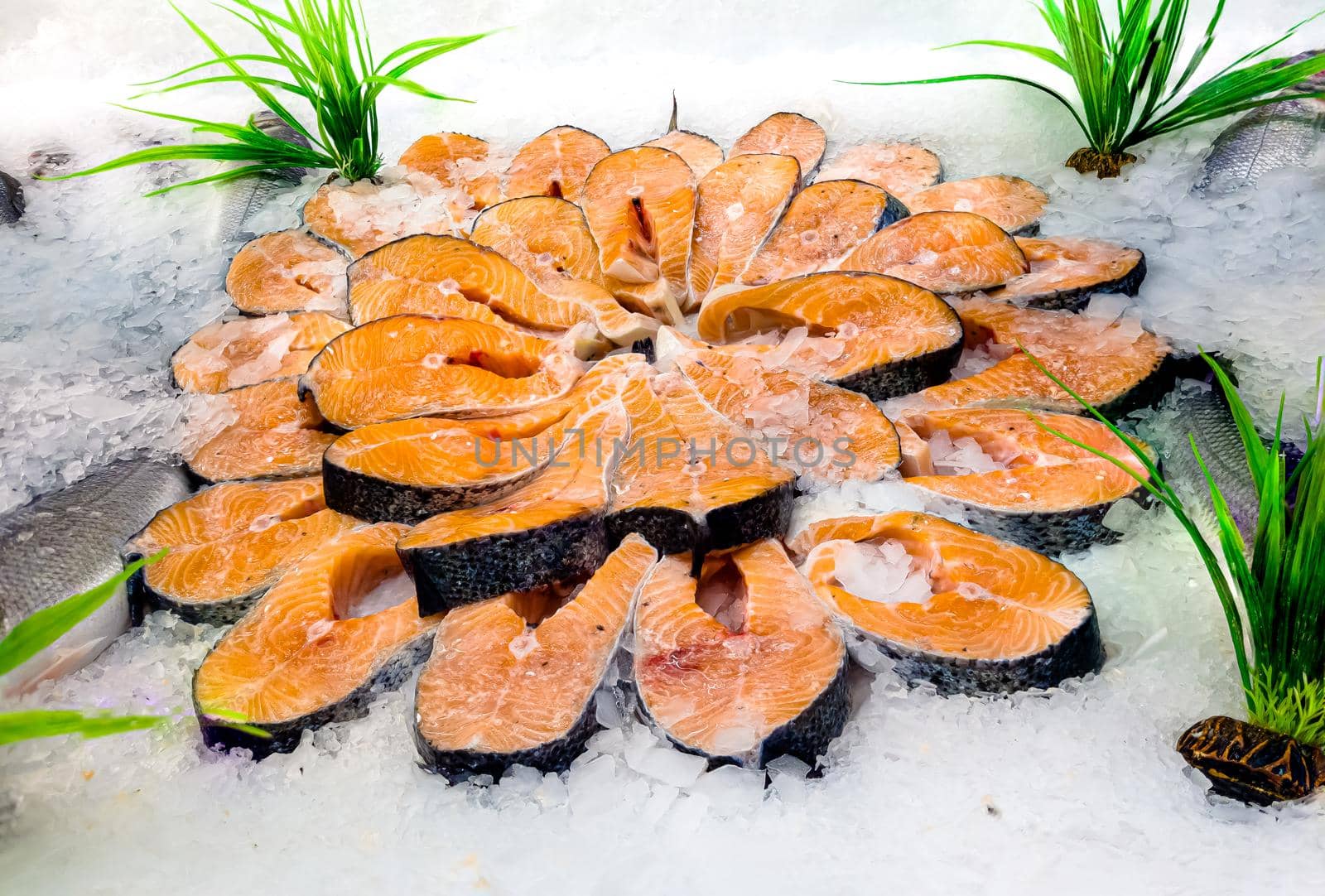 Salmon steaks lie on ice on the counter in a fish store by Milanchikov