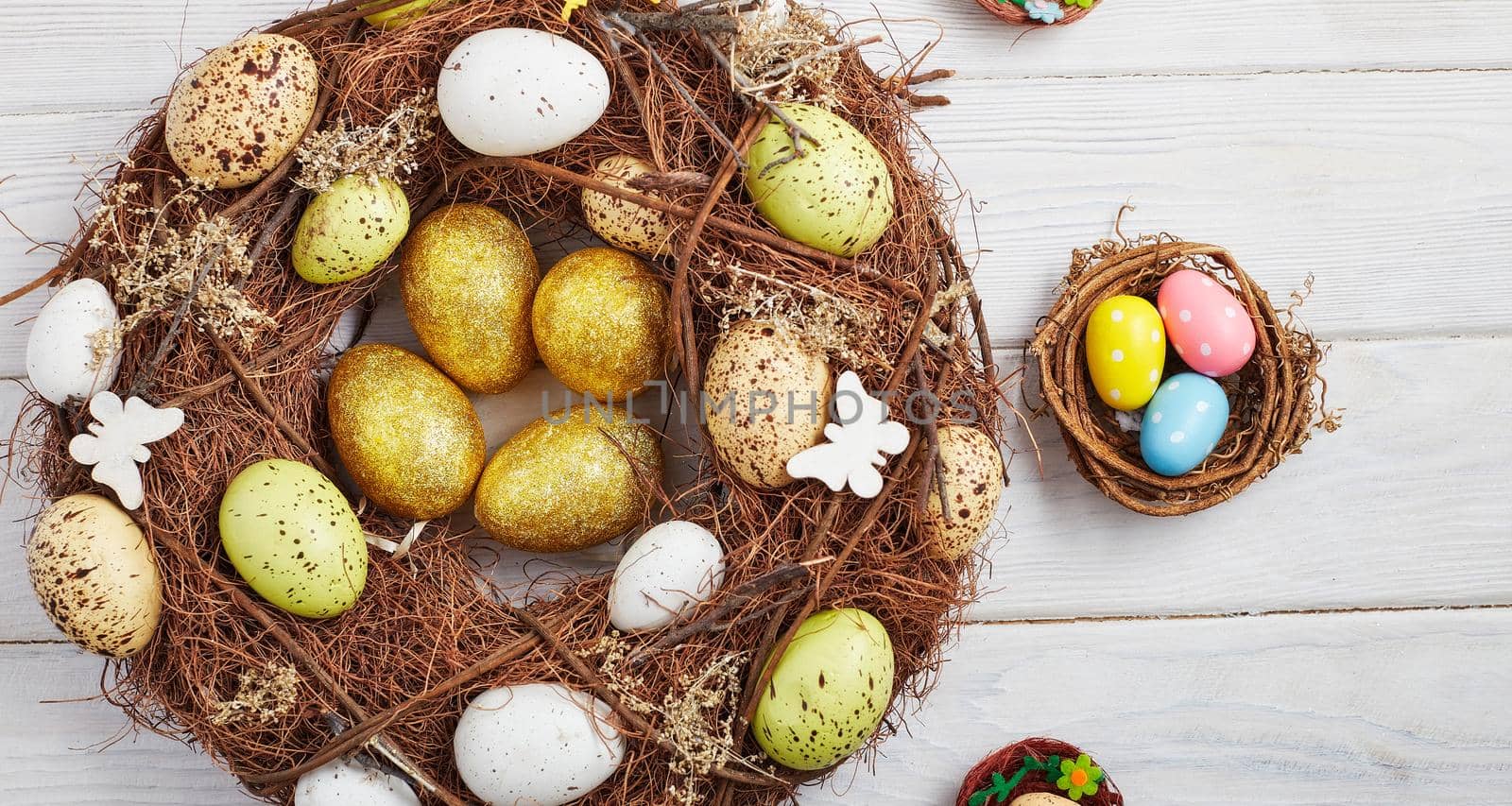 Coloeful easter eggs in nest on pink color background with space. Minimal concept. Card with copy space for text.