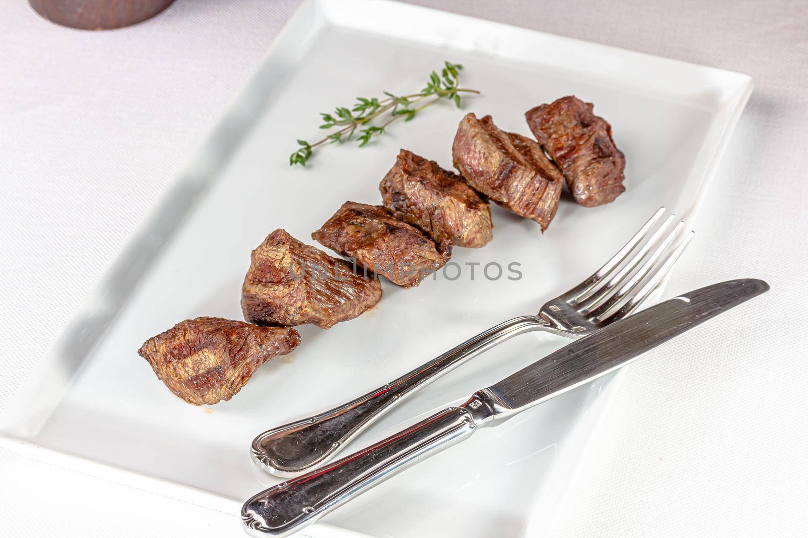 Beef kebab with tomato sauce with vegetables is on a plate by Milanchikov