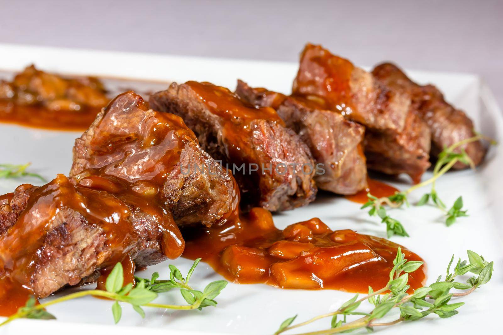 Beef kebab with tomato sauce with vegetables is on a plate by Milanchikov