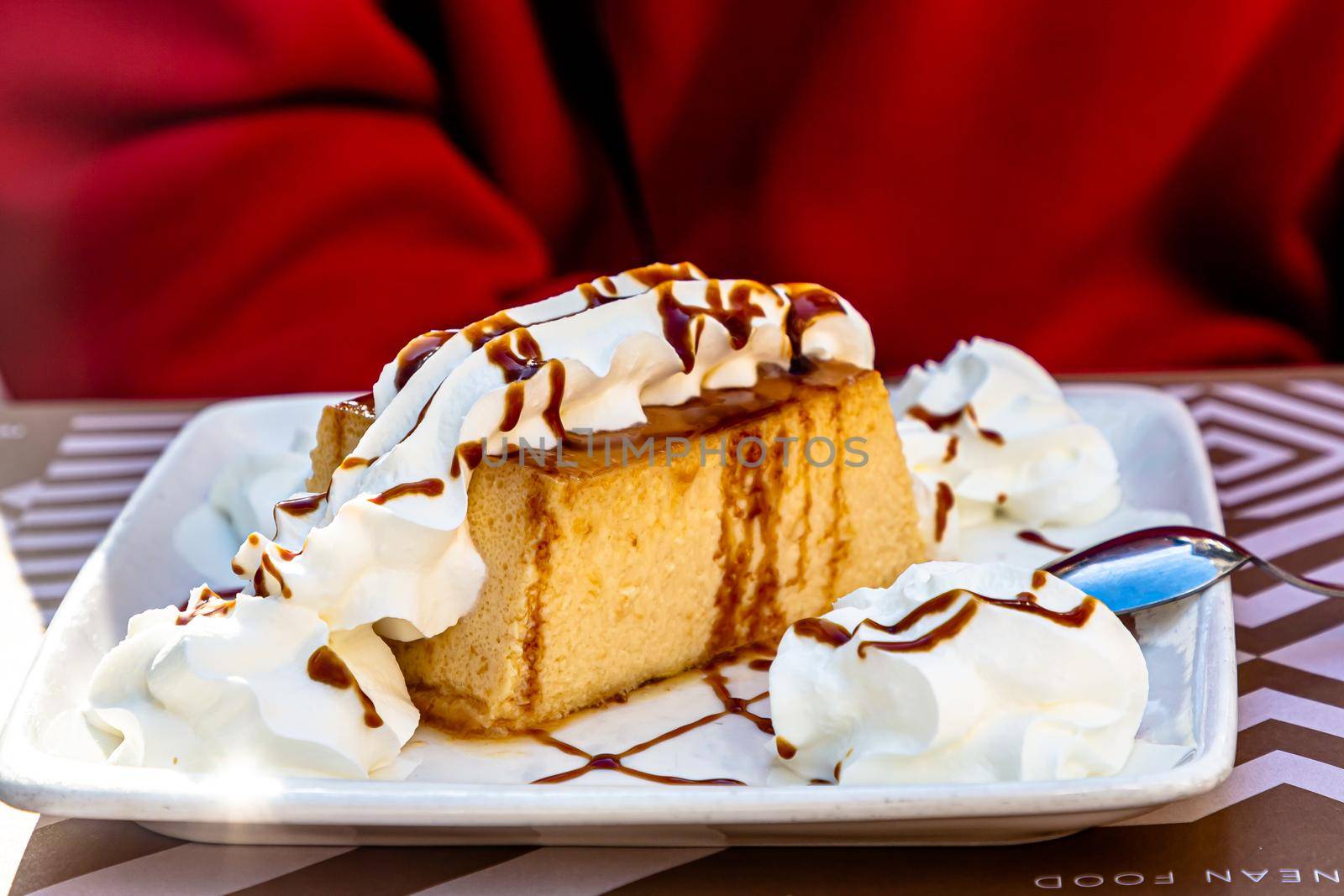 Dessert. A sponge cake with whipped cream and chocolate is on a plate