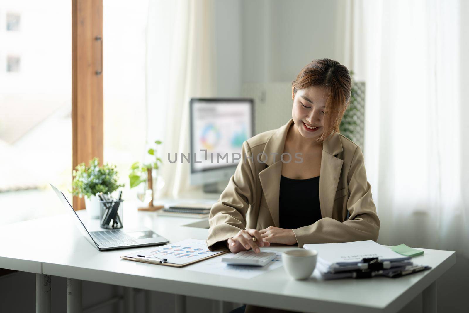 Attractive business asian women using calculator at working with financial report