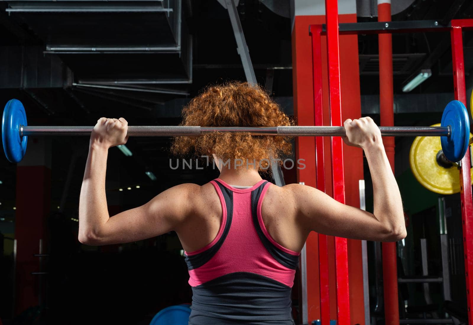 Woman bodybuilder engaged with a barbell in the gym by adam121