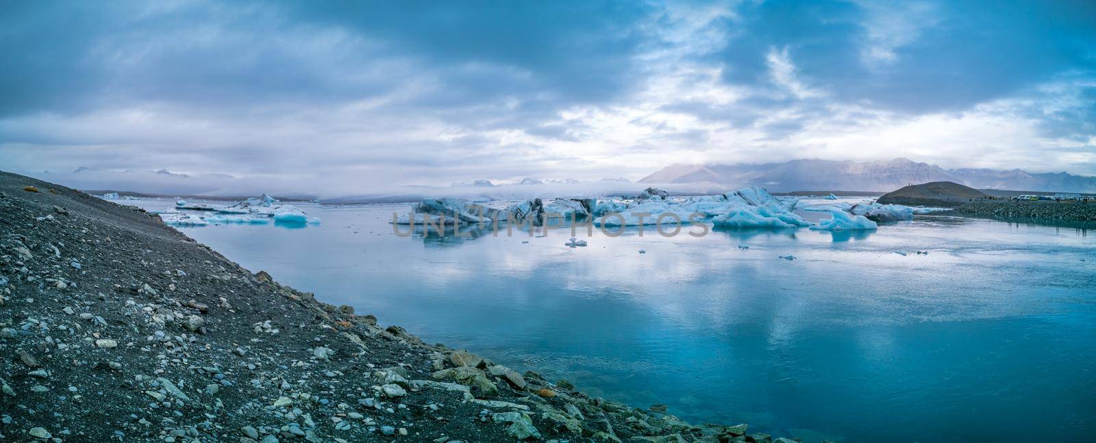 Panoramic view of jokulsarlon lagoon exit canal with icebergs