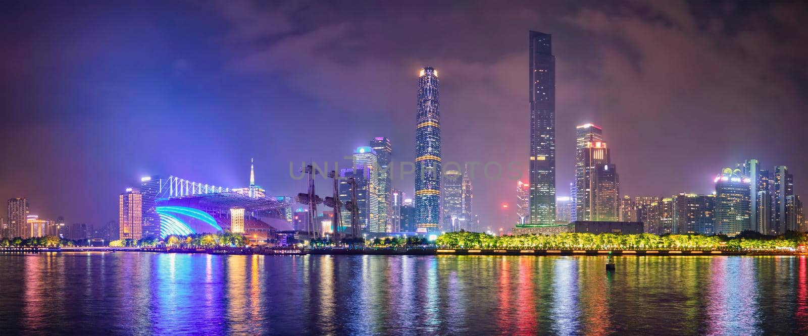 Guangzhou cityscape skyline over the Pearl River illuminated in the evening. Guangzhou, China