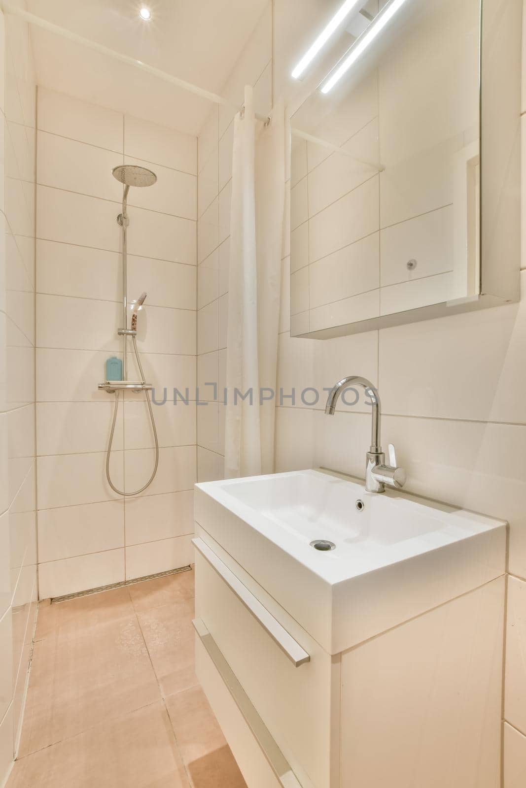 Bathroom interior with ceramic sink and shower surrounded by white tiles