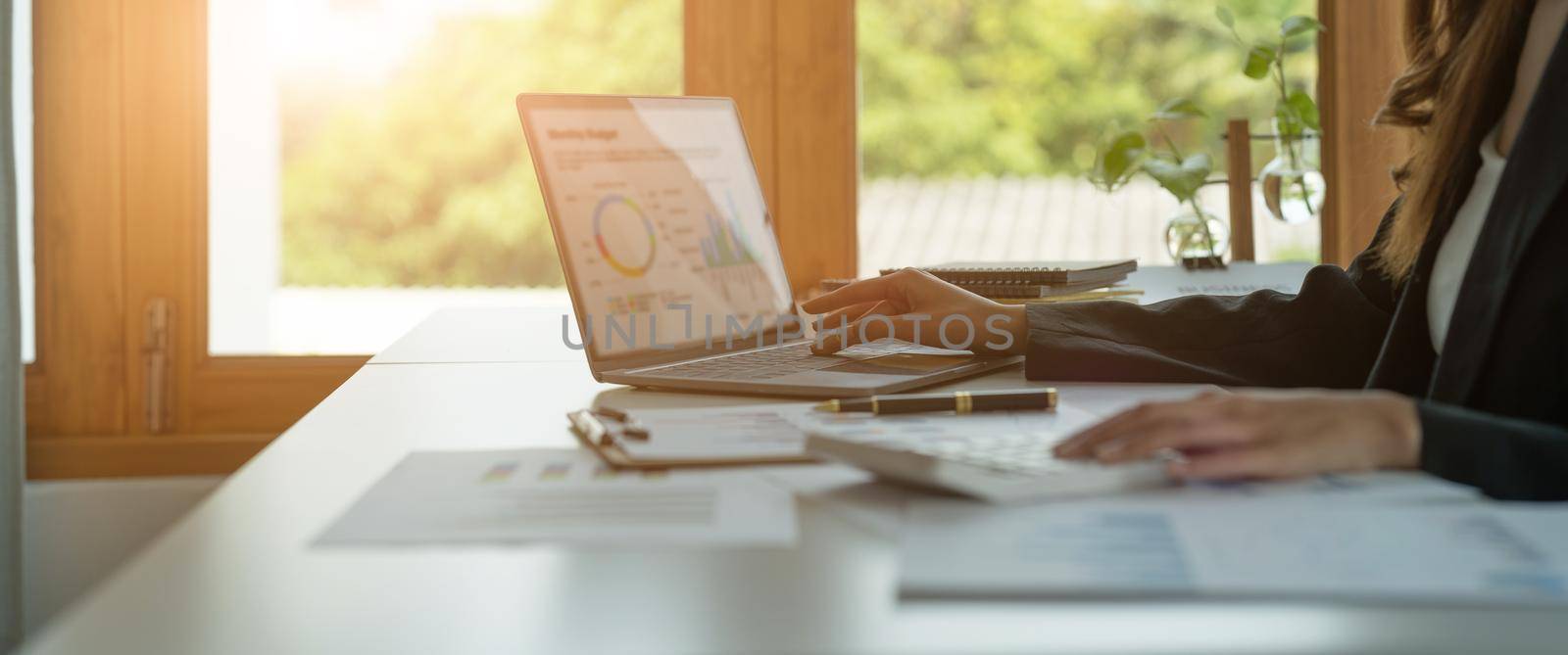 Business woman calculating domestic expenses involved in financial paperwork indoors, focused lady managing monthly banking payments summarizing utility bills and taxes at home.